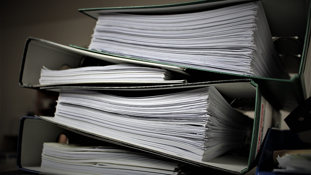 many documents in a black three-hole binder