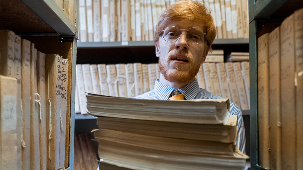 A man in a large storage facility for old documents